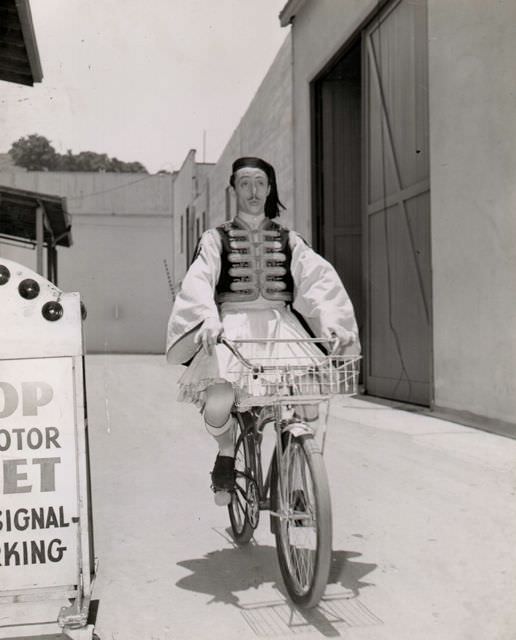 Mischa Auer riding a bike.