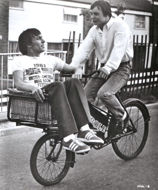 Christopher Timothy and Barry Evans ride a bike, ‘round the mulberry bush.