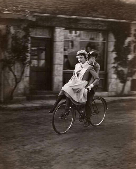 Jennifer Jones and Brad Slaven ride a bike.