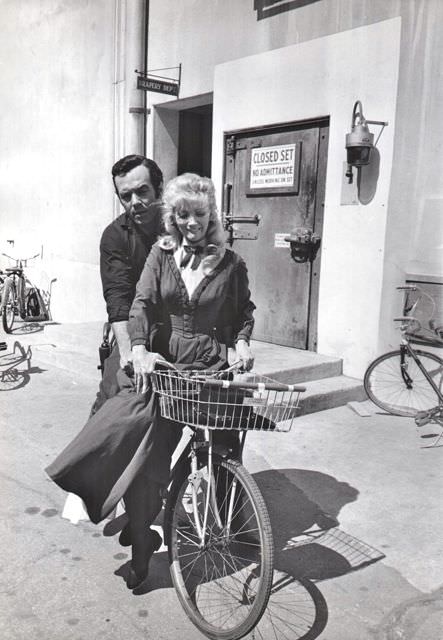 Pernell Roberts and Kathie Browne ride a bike.
