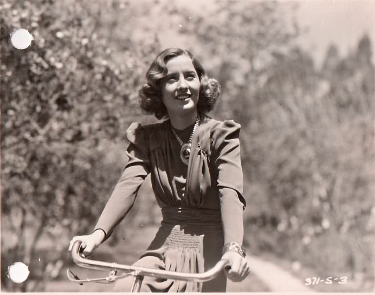Barbara Stanwyck riding a bike.