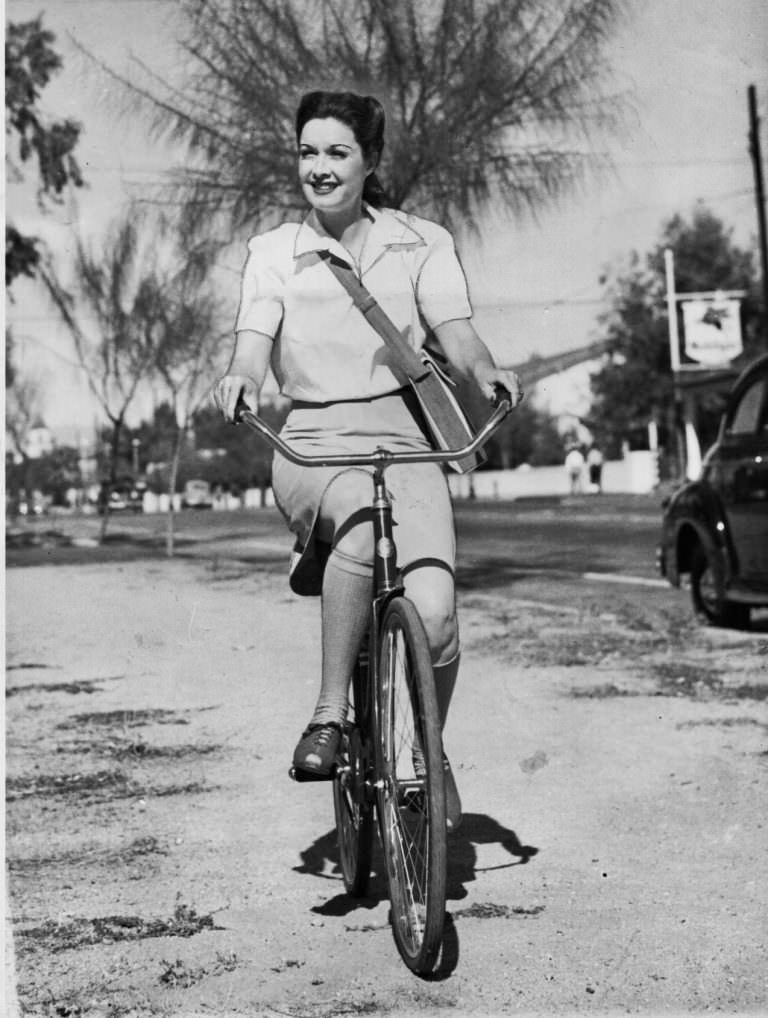 Gail Patrick riding a bike.