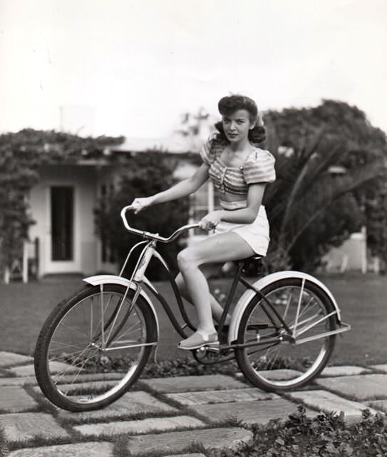Ida Lupino riding a bike.