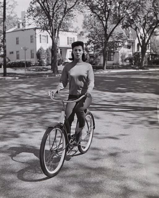 Rita Gam riding a bike.
