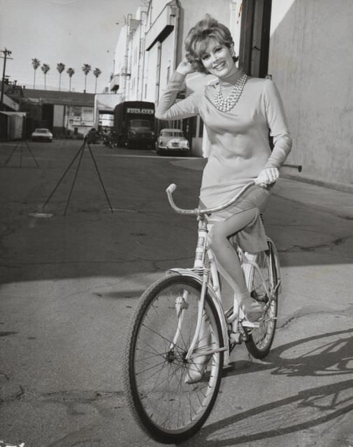 Jill St. John riding a bike.