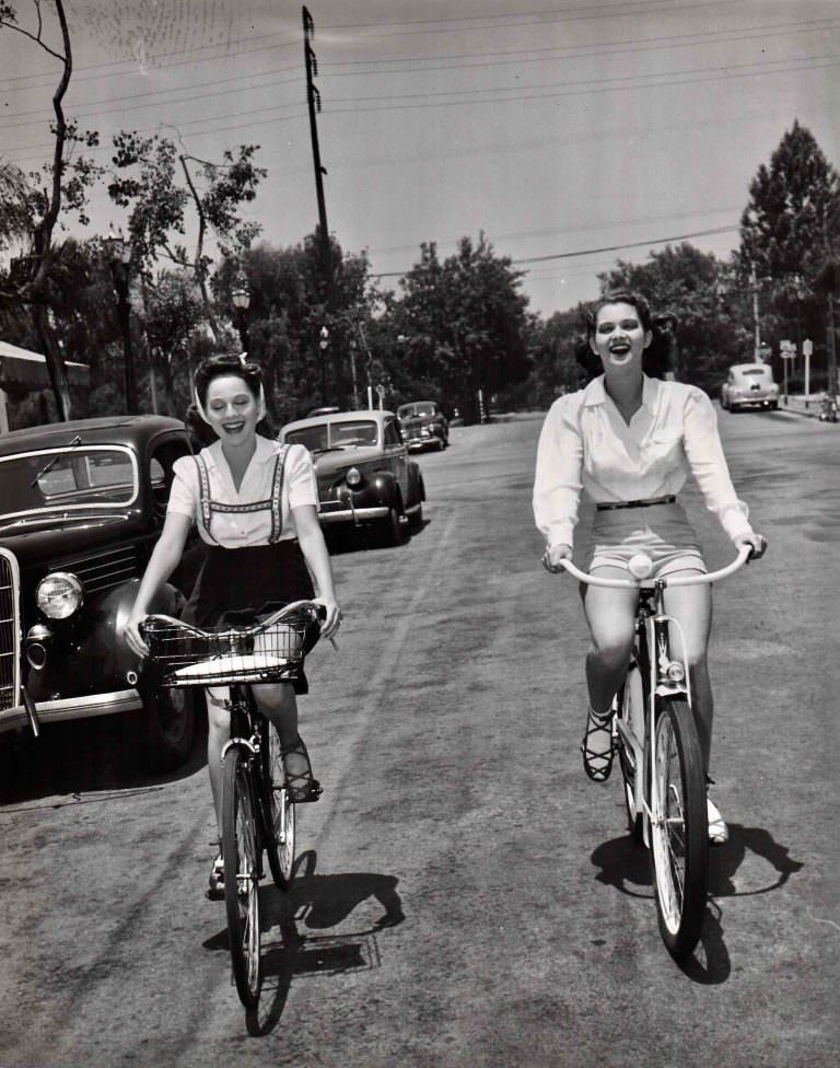Dorothy Morris and Frances Rafferty ride bikes.