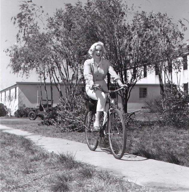 Mamie Van Doren riding a bike.