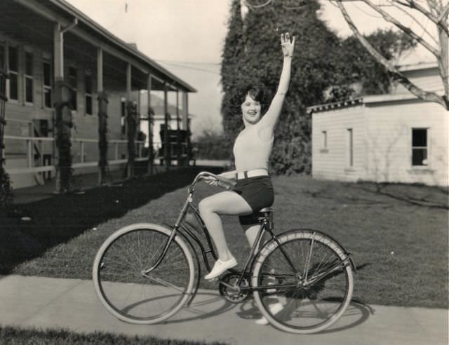 Margaret Livingston riding a bike, waves hello. On the lot in 1924, three years before “Sunrise.”