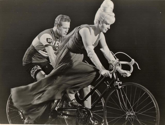 Joanne Woodward and Paul Newman ride bikes.