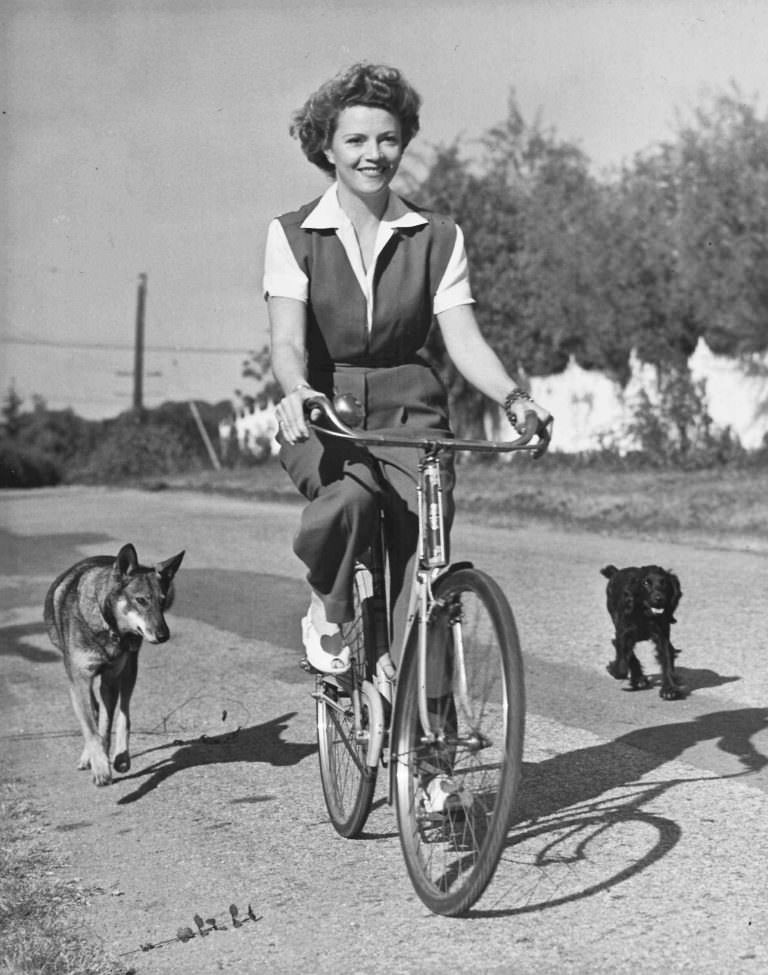 Annabella riding a bike, with dogs.