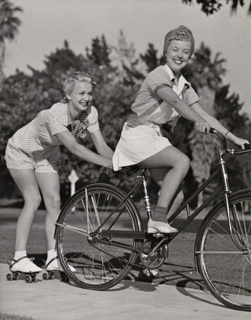 Phyllis Ruth riding a bike, Carole Landis skitches on skates.