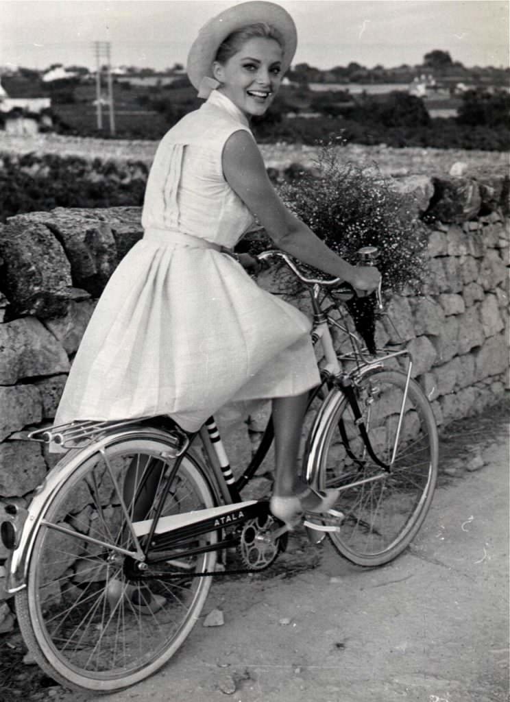 Virna Lisi riding a bike.