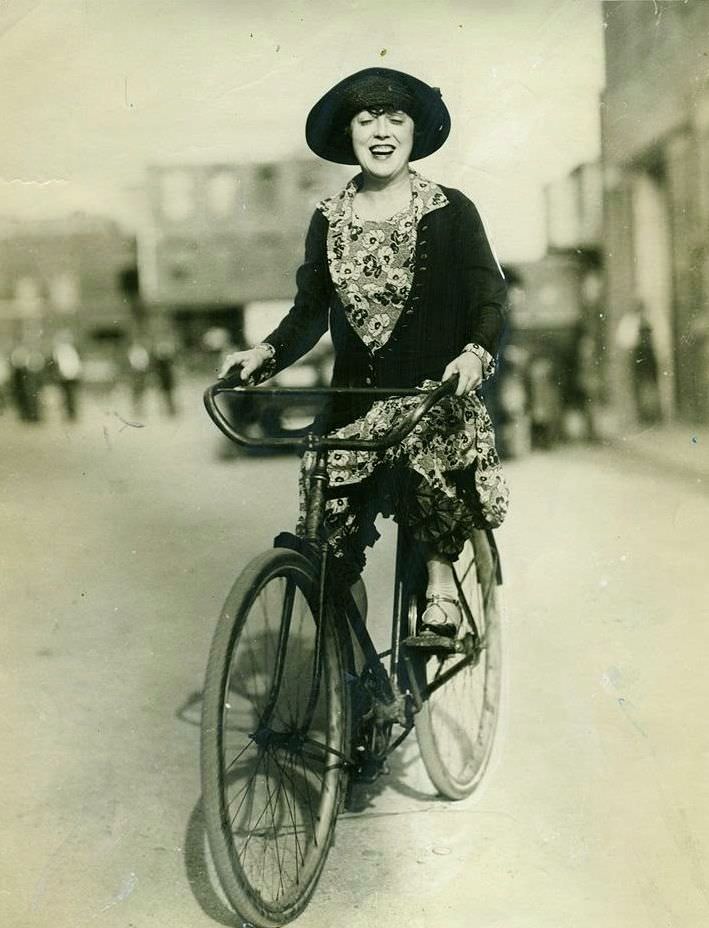 Mabel Normand riding a bike.