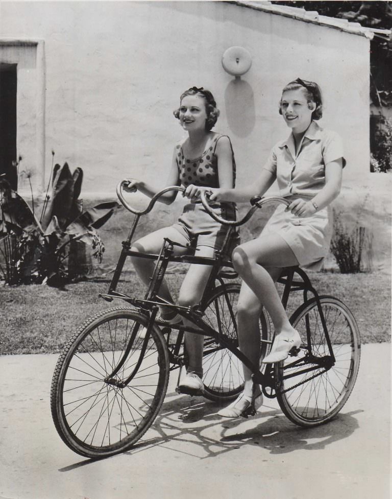 Jean Howard and Irene Hervey ride a buddy bike.