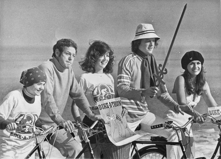 Sandra Eisele, James MacArthur, Kathy Jordan, Bob Sirott and Gloria Besbekis posing with bikes.