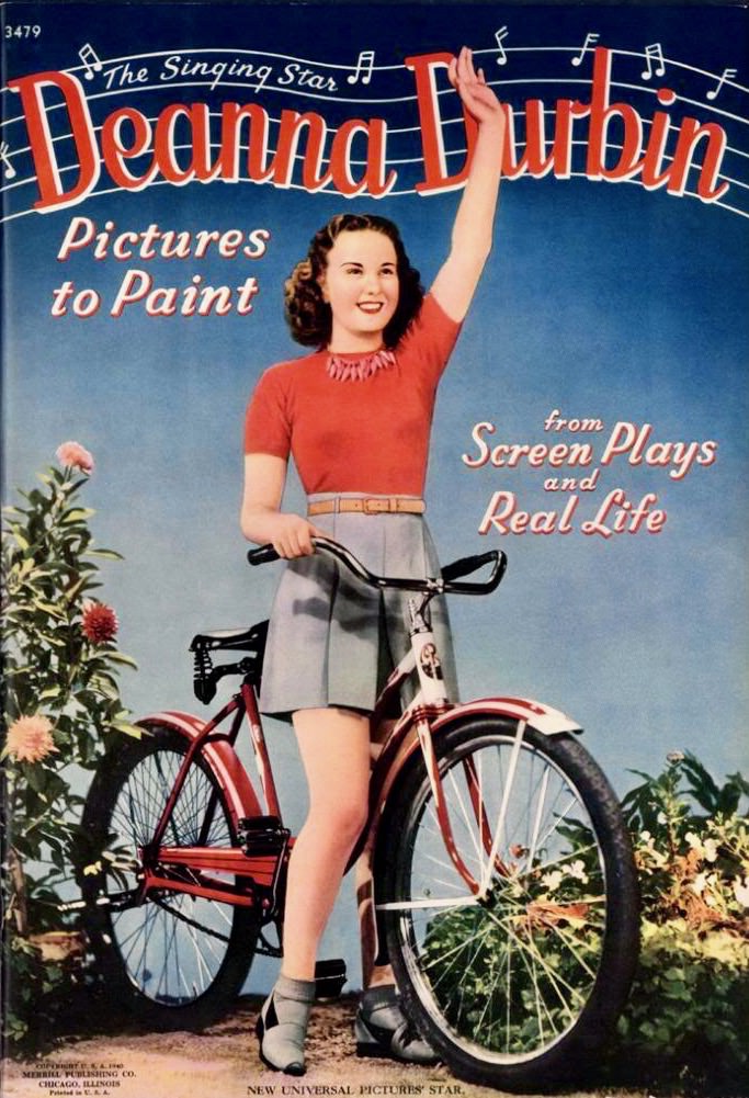 Betsy Drake rests a bike, beach-side.