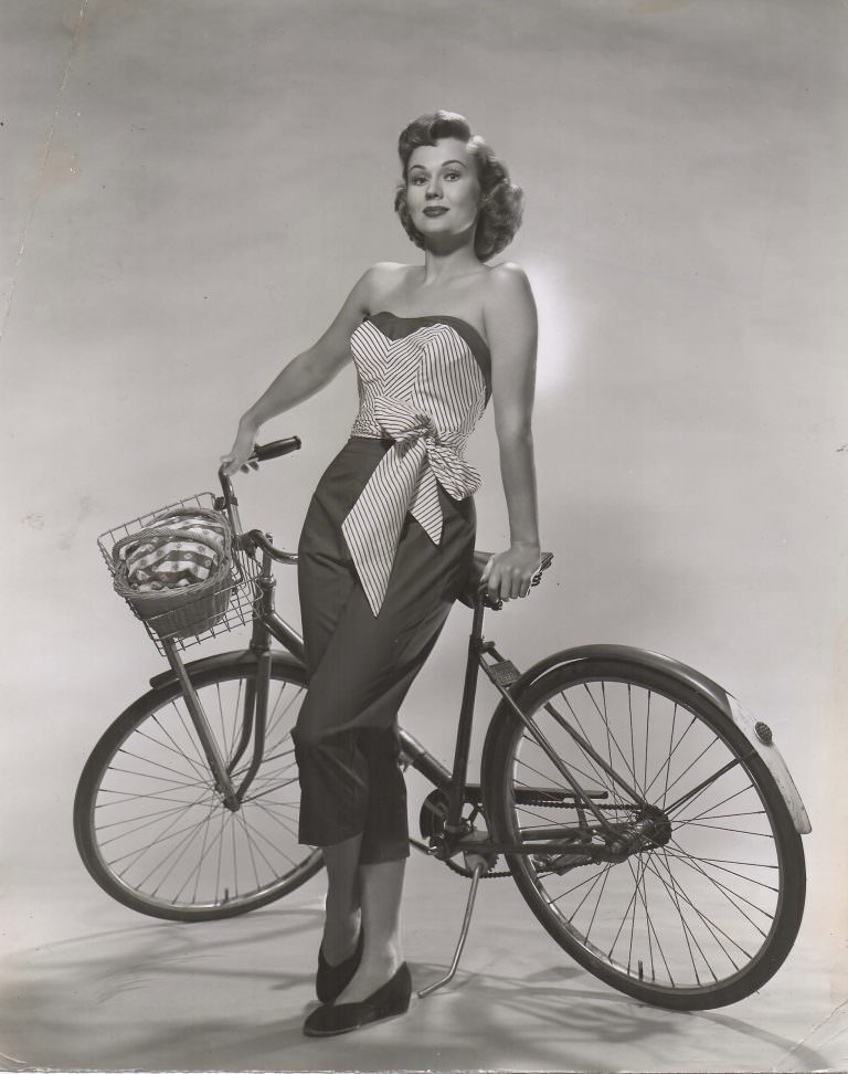 Virginia Mayo poses with bike.