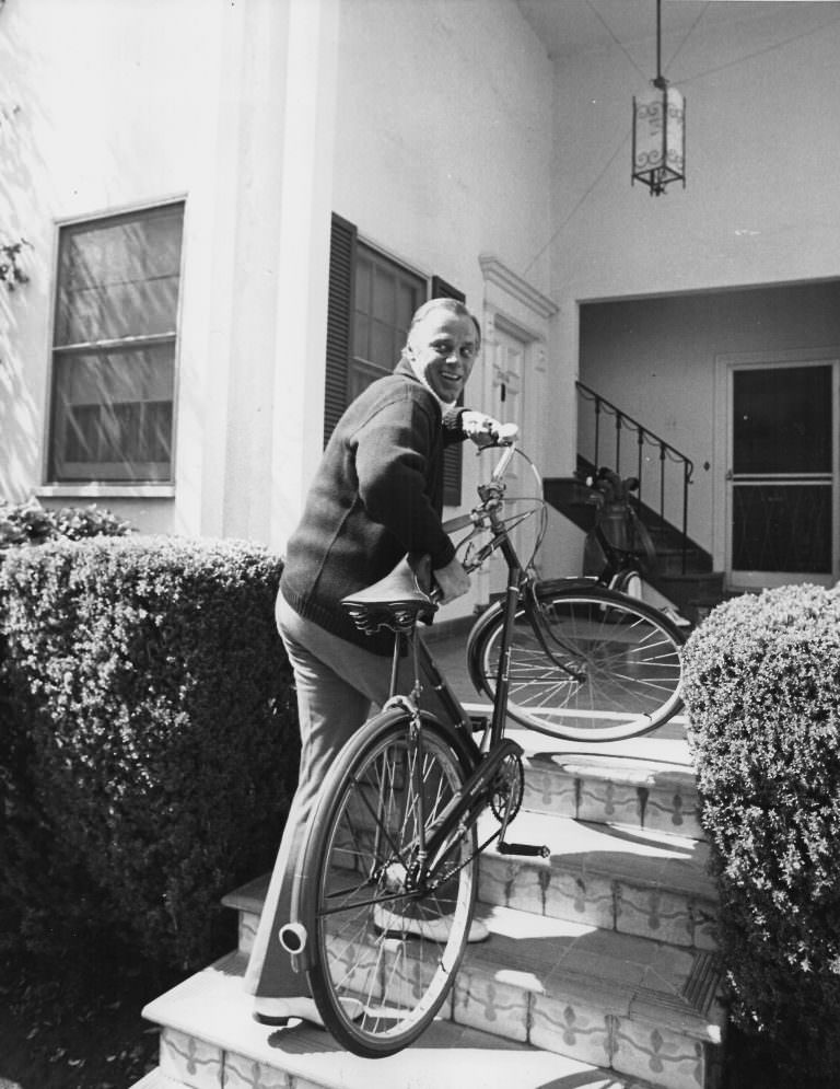 McLean Stevenson carries a bike.