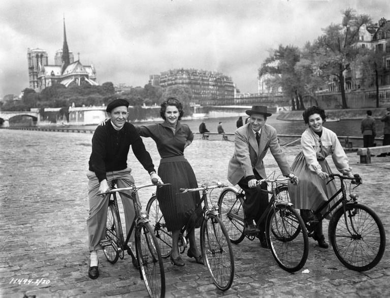 Bing Crosby, Nicole Maurey, Claude Dauphin and Maria Mauban posing with their bikes.