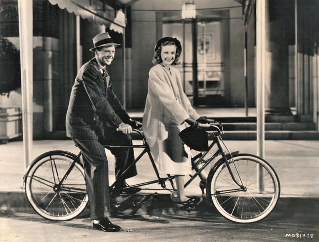 Dan Dailey and Virginia Grey ride on their bikes.