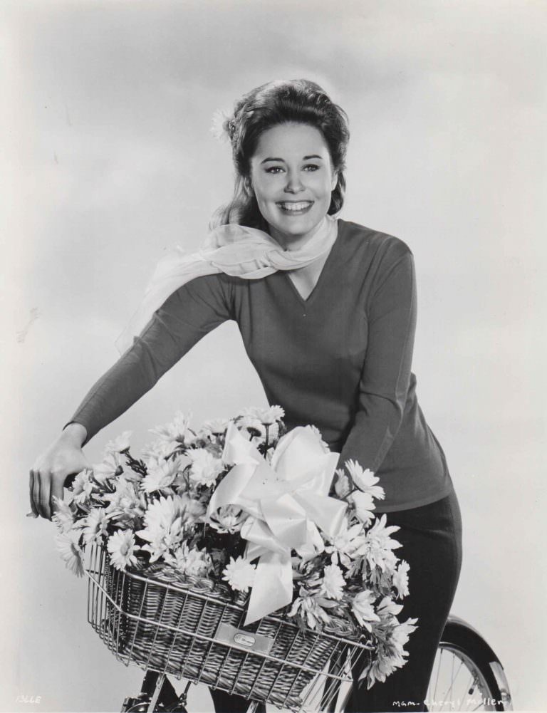 Cheryl Miller posing on a bike, florally.