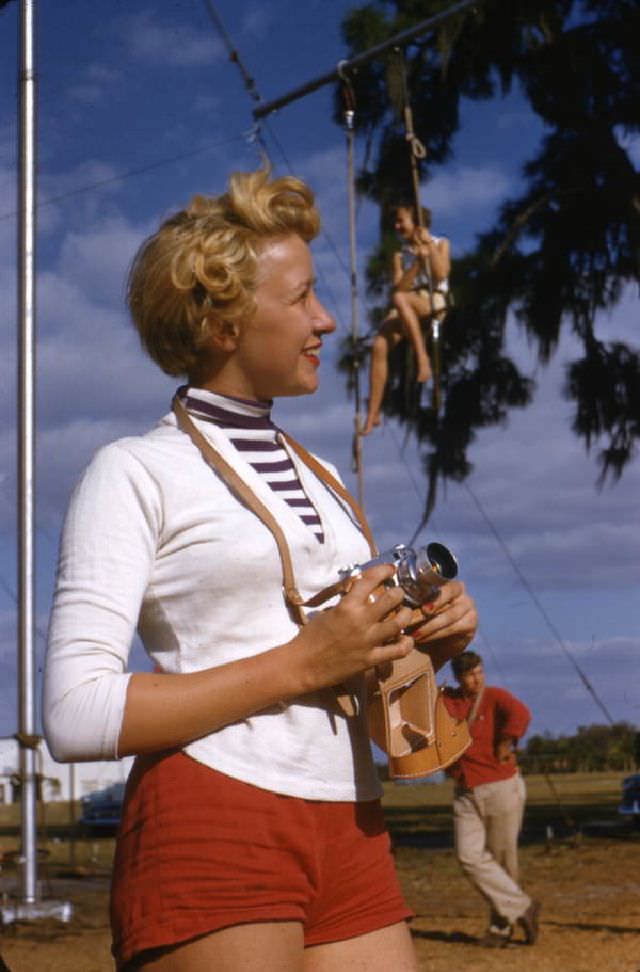 Sailor Circus acrobatic performer Judy Laurent with a camera, Sarasota, 1955