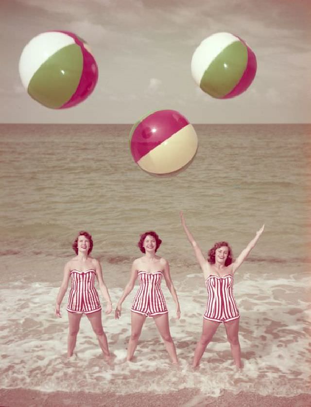 Women modeling bathing suits at the beach, circa 1955