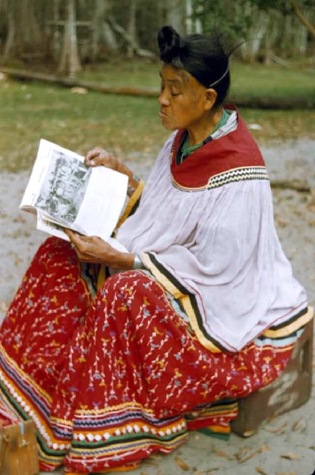 Seminole woman reading at Big Cypress Reservaton, circa 1958