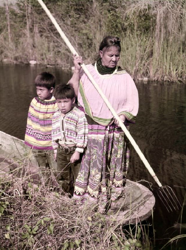 Seminole woman and children gigging frogs near the Tamiami Trail, January 3, 1951