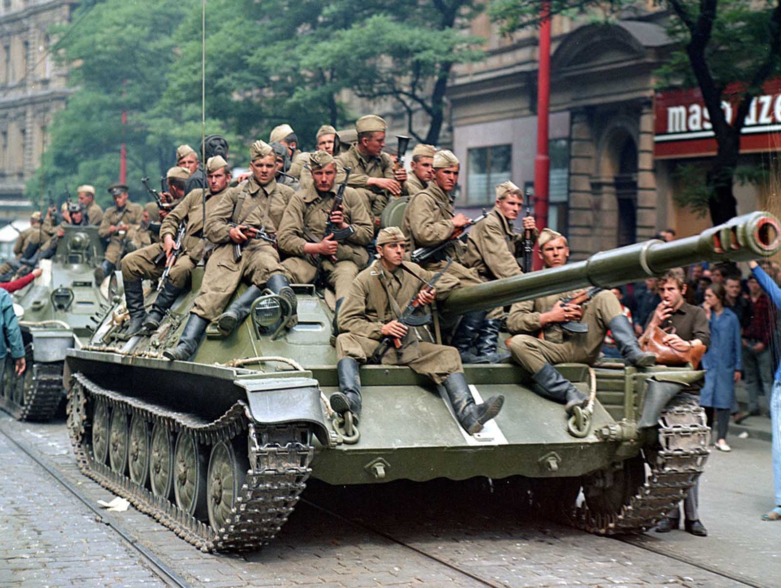 Soviet army soldiers sit on their tanks in front of the Czechoslovak Radio building, in central Prague, on August 21, 1968.