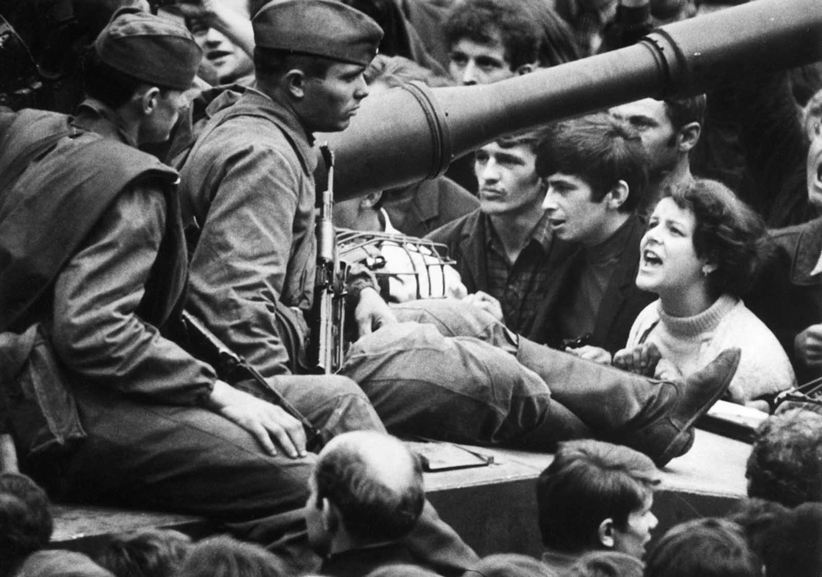 A young Czech lets her feelings be known as she shouts at Soviet soldiers sitting on tanks in the streets of Prague on August 26, 1968.