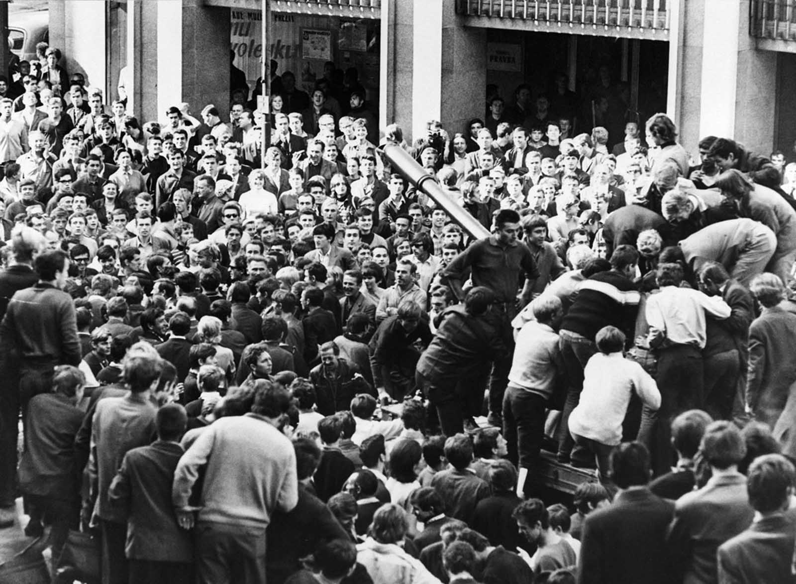 Angry citizens surround a Soviet tank and climb its turret to mock the crew in Bratislava, Czechoslovakia, on August 22, 1968.