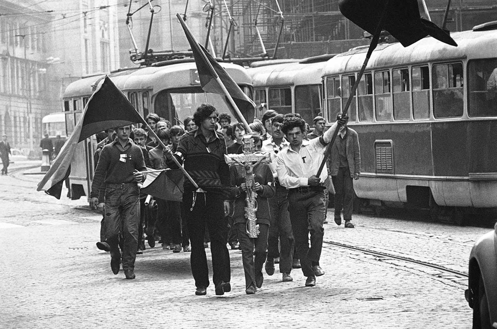 Youths carry a crucifix on their way to the burial of a friend shot by the Soviets on August 27, 1968, in Prague.