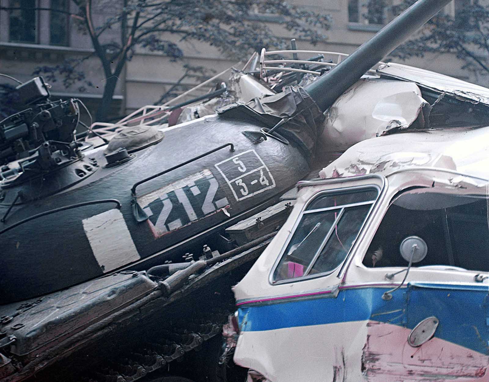 A Soviet army tank rolls over a barricade made from trucks and buses in front of the Czechoslovak Radio building on August 21, 1968.