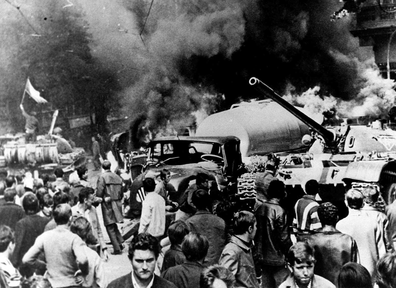 A Soviet tank, burning vehicles, and sullen citizens are seen in Prague on August 21, 1968, as Soviet troops entered the Czechoslovakian capital.