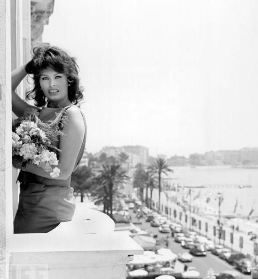 Sophia Loren poses with flowers on the balcony of her Cannes hotel on May 13, 1959.