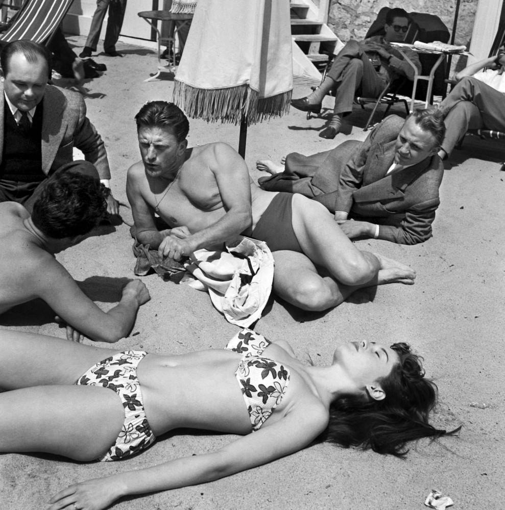 Kirk Douglas on the beach at Cannes with a young actress Brigitte Bardot during the 6th International Cannes Film Festival, 1953.