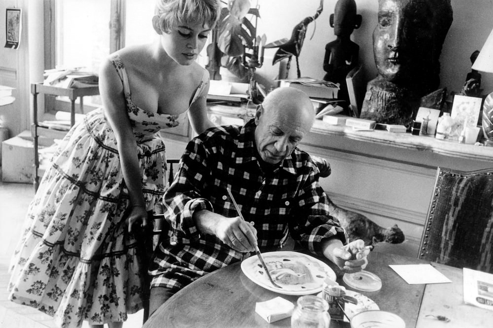 Actress Brigitte Bardot watching Pablo Picasso at work in his studio in Vallauris during the 1956 International Cannes Film Festival.