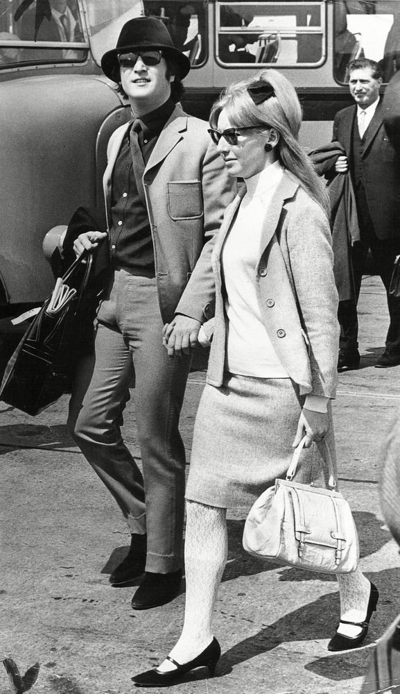 John Lennon flies out to the Cannes Film Festival with his first wife Cynthia Lennon allegedly icognito wearing dark glasses and a green velour hat, 1965.