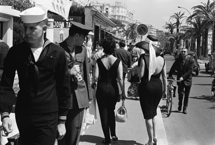 An American serviceman admires passersby on the street in Cannes, 1962.