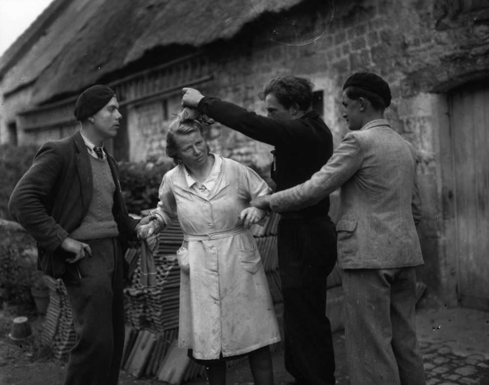 Two French patriots restrain a woman while another crops her hair after she has been accused of collaborating with the Germans during the occupation. January 01, 1945.