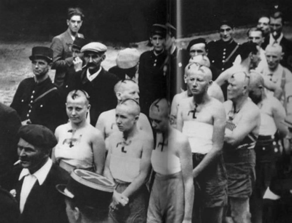 Women with their tops torn off and swastikas scrawled with tar on their faces are paraded through the streets of Paris. Many other women were dragged through the streets naked.