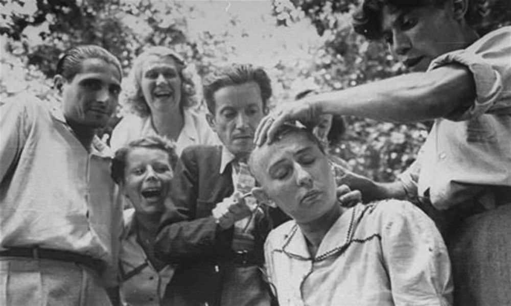 A crowd jeers as a woman’s head is shaved during the liberation of Marseilles.