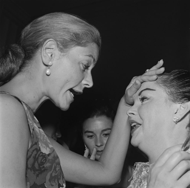 Lauren Bacall feels the forehead of actress and singer Judy Garland at an event, circa 1965.