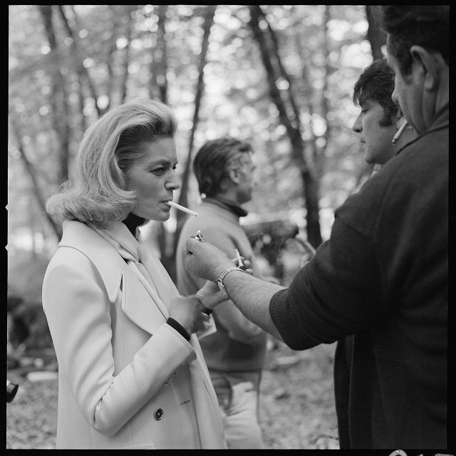 Lauren Bacall has her cigarette lighted for her during an off-camera moment during the filming of the CBS special 'The Paris Collections Fall Fashion Preview,' June 1968.