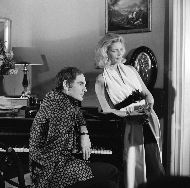 Fashion designer Pierre Cardin and Lauren Bacall pose near a piano for the CBS special 'The Paris Collections Fall Fashion Preview,' June 1968.