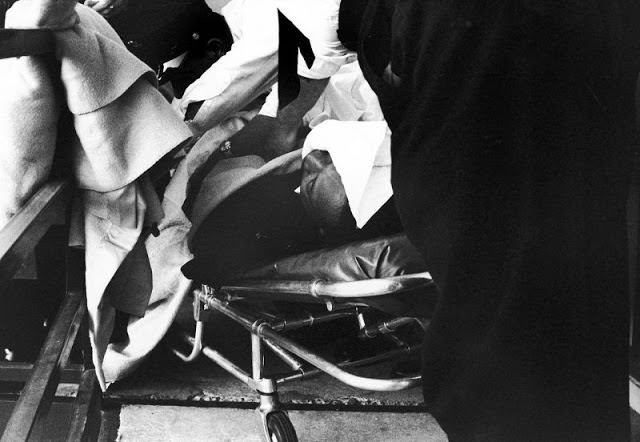 An unidentified man uses a blanket to cover the body of Martin Luther King, Jr., moments after he was shot in the face.
