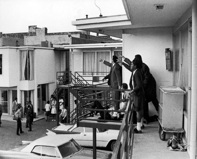 Civil rights leader Andrew Young (L) and others standing on balcony of Lorraine motel pointing in direction of assailant after assassination of civil rights ldr. Dr. Martin Luther King, Jr., who is lying at their feet.
