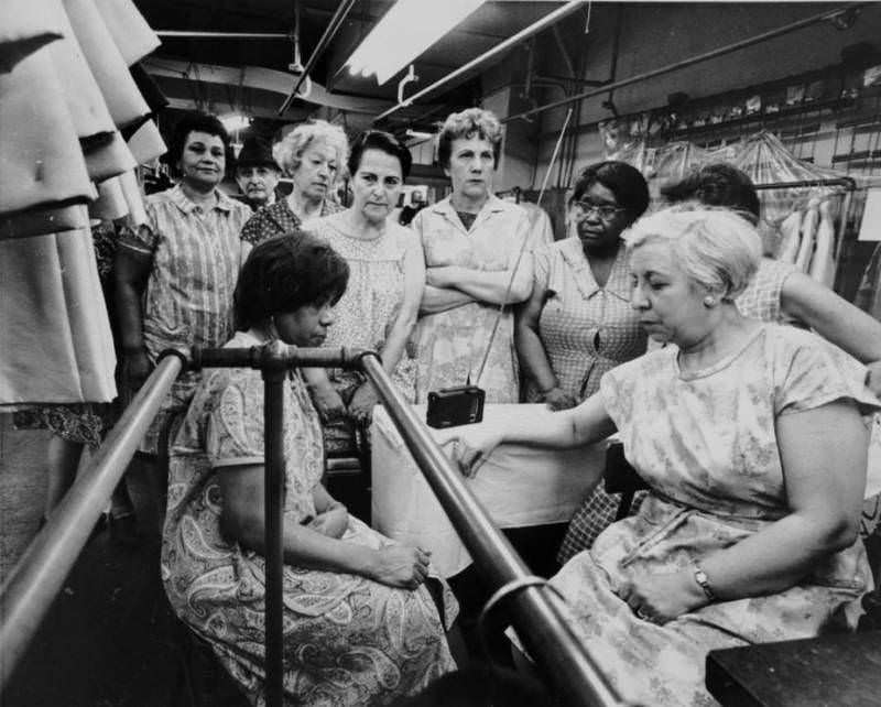 Women at the Abe Schrader clothing shop in New York pause during work to listen to the funeral service for Martin Luther King Jr. on a portable radio. April 8, 1968. Memphis, Tennessee.