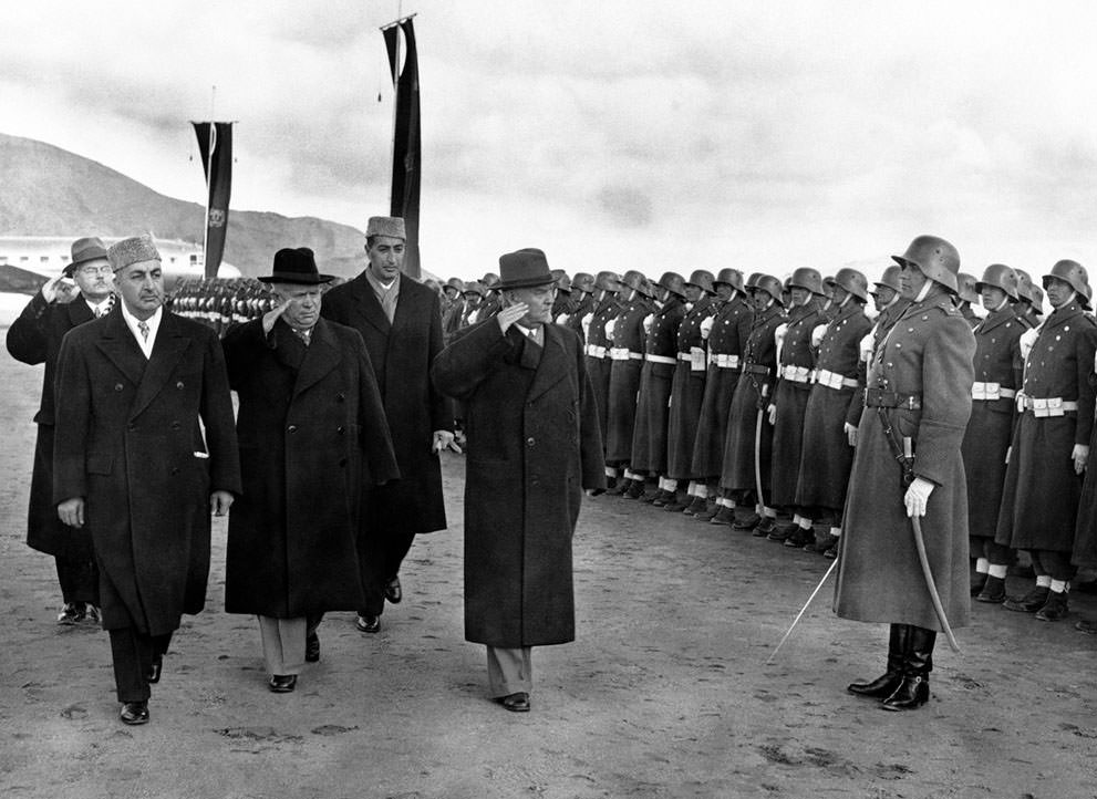 Soviet leader Nikita Khrushchev (black hat), and Marshal Nikolai Bulganin review an Afghan honor guard wearing old German uniforms, on their arrival in Kabul, Afghanistan, on December 15, 1955.